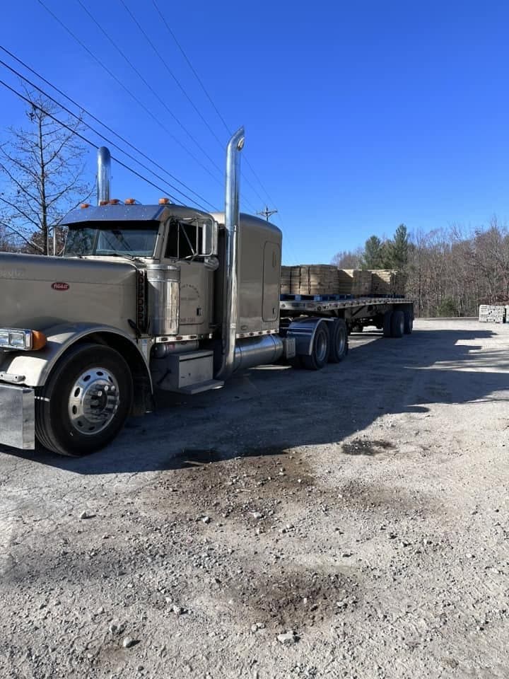 Flatbed truck loaded with Deer Creek Stone pallets for delivery