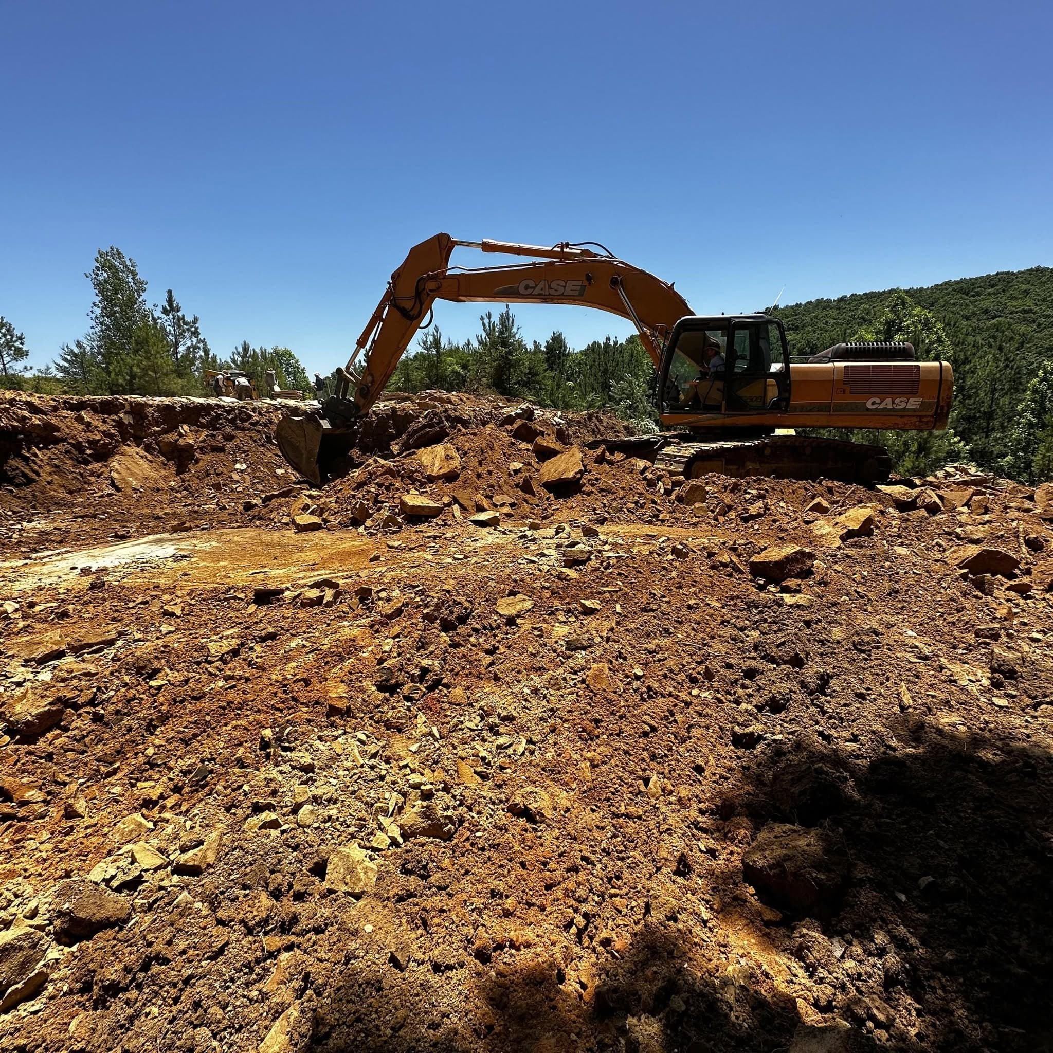 Excavator clearing ground at the Deer Creek Stone quarry